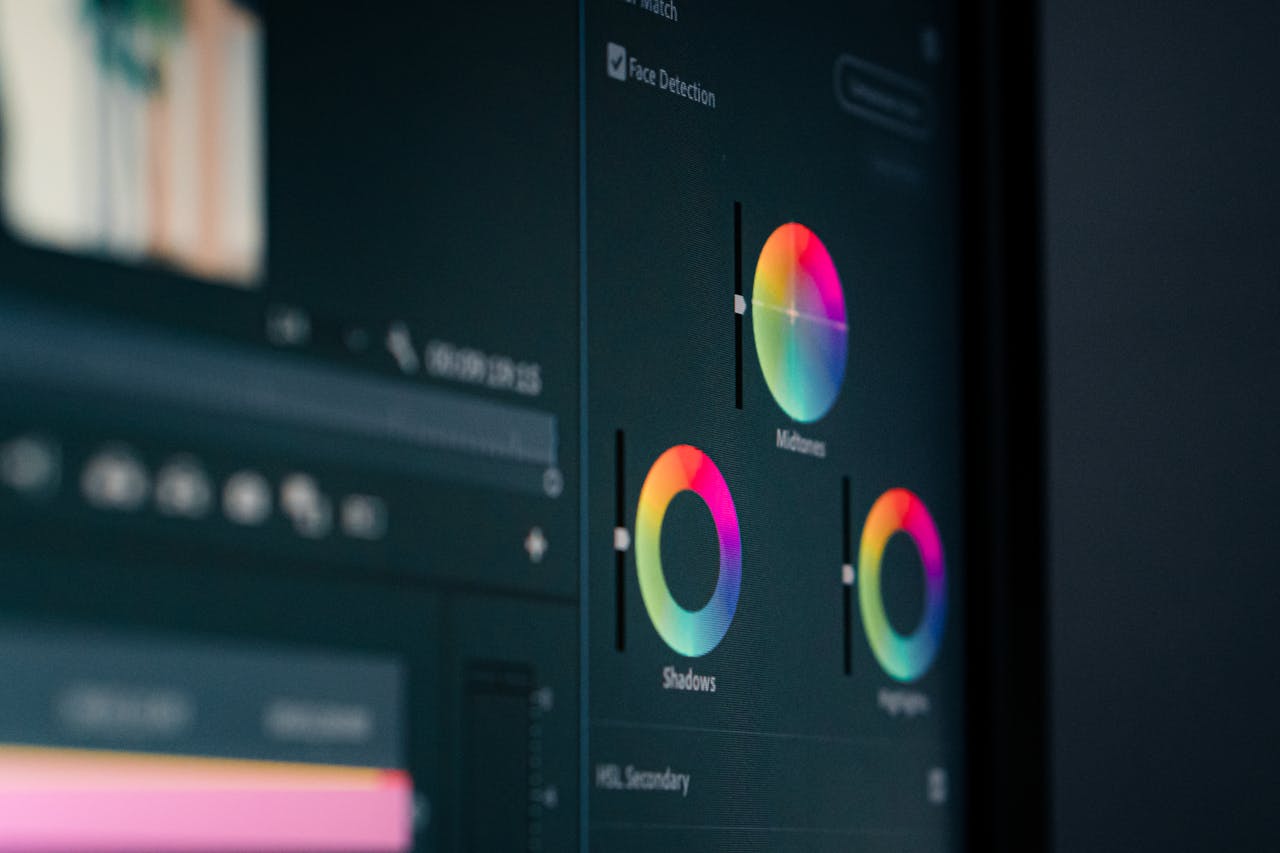 services-04 Close-up of color grading wheels on a monitor, showcasing digital editing in vibrant hues.
