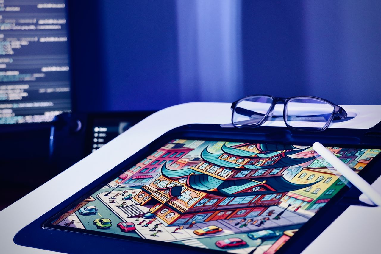 who-we-are Digital artwork on a tablet with stylus and glasses in a creative setting.